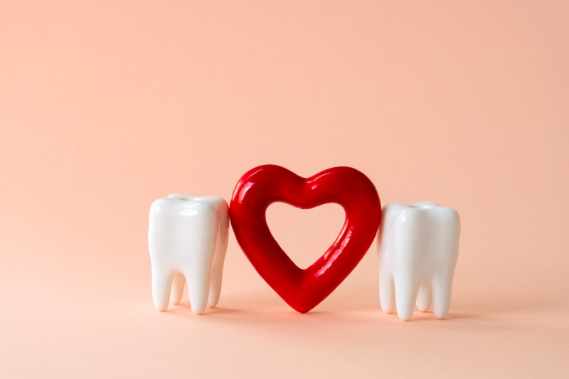 Two Teeth Holding a Heart Celebrating National Dentists Day on March 6