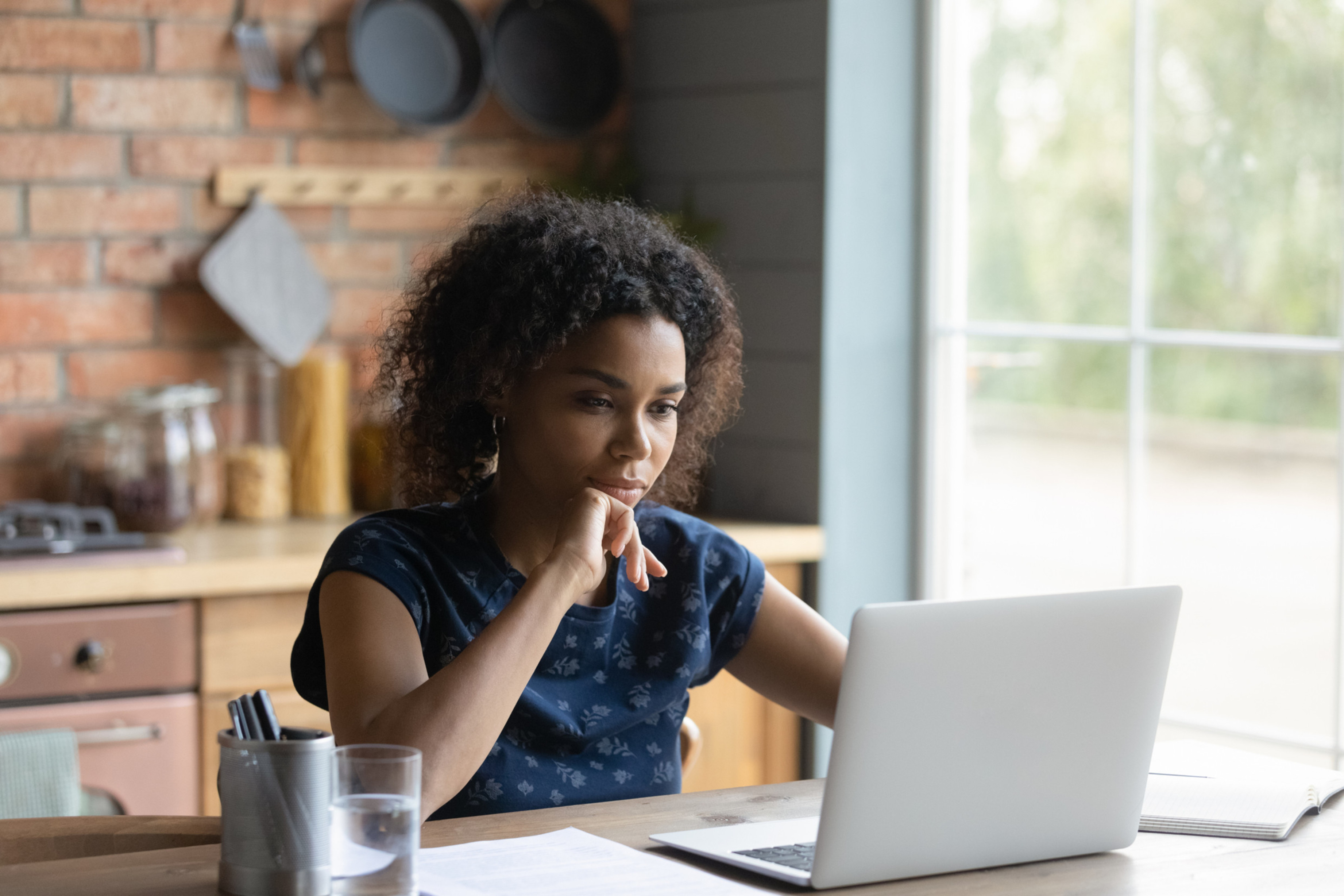 Woman sitting at table with laptop buying Berxi insurance