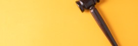 Plain brown gavel against yellow background