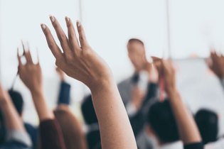 healthcare professionals raising hands asking questions