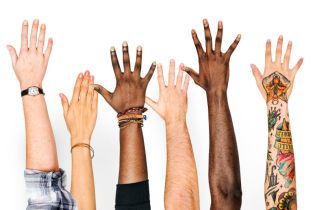 group of diverse hands reaching up