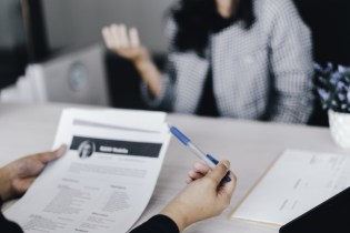 interviewer looking at business womans resume not asking illegal interview questions