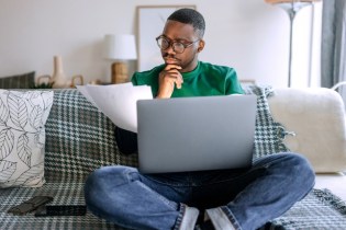 man sitting on couch reviewing the limits of liability insurance