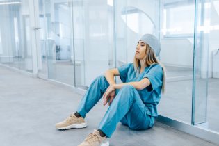 nurse sitting in blue scrubs during a nursing shortage