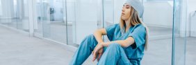 nurse sitting in blue scrubs during a nursing shortage