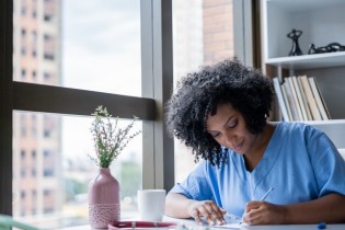 nurse writing on desk | best nurse entrepreneurs