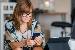 woman on phone looking at best free apps for small business owners