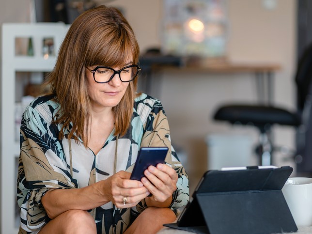woman on phone looking at best free apps for small business owners