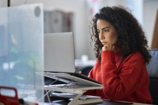 woman looking on computer at claims made vs occurrence policies