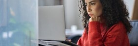 woman looking on computer at claims made vs occurrence policies