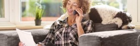 woman on phone with dog behind her buying professional liability insurance direct