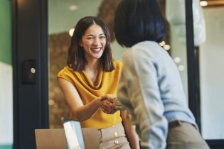 woman smiling shaking other woman's hand | insurance claims team must-haves