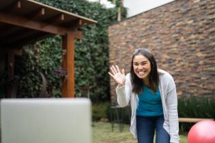 physical therapy influencer waving outside at laptop