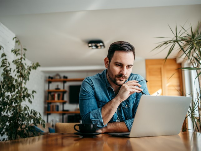 man searching on his laptop for types of liability insurance for small business