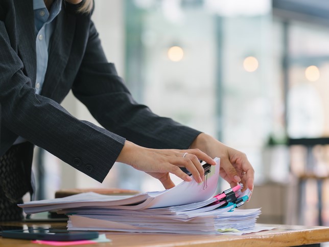 woman going through a stack of papers | errors and omissions insurance for bookkeepers cost 